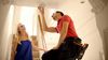 Woman watching man install a smoke detector.