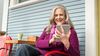 A woman sitting outside and reading about borrowing against a life insurance policy on her tablet.