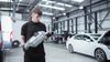 Technician holding a catalytic converter in a repair center.