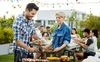 Man serves food from grill to friend.