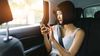 Woman in a rideshare researching common rideshare insurance misconceptions.