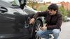 Young man examining the damage to his vehicle following a car accident.
