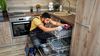 Plumber doing an appliance repair on a dishwasher.