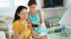 Girl and mother using smart phone to deposit a check.