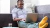 A millennial aged man working on his laptop
