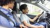 Mother teaching son how to drive a car.