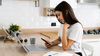 Young woman in her kitchen reviewing her insurance policies.