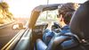 Young man driving a convertible sports car on a summer day.