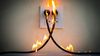 Electrical cords plugged into the wall are on fire due to an arc flash.