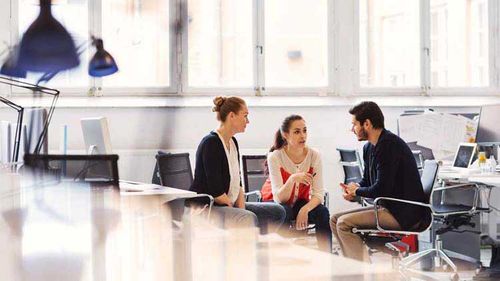Employees seated in an office discussing simplified employee pension plans.
