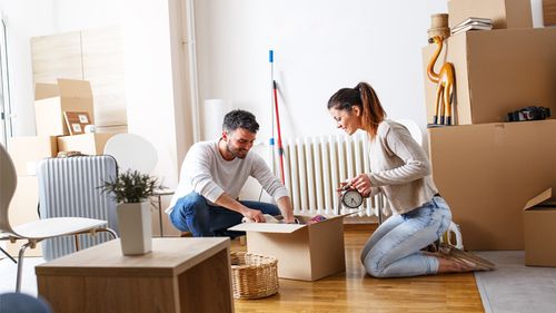 Young couple unpacking boxes at their new apartment.