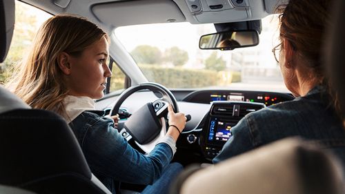 Teenager learning about driving rules from her parent.