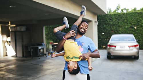 Dad and son having fun in the driveway.