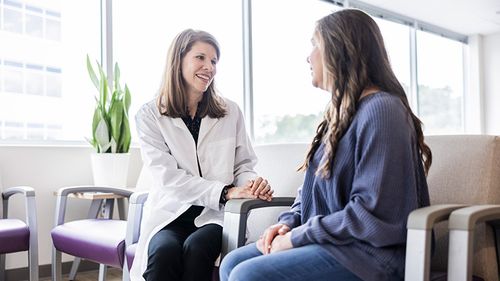 A medical professional talks with a patient.